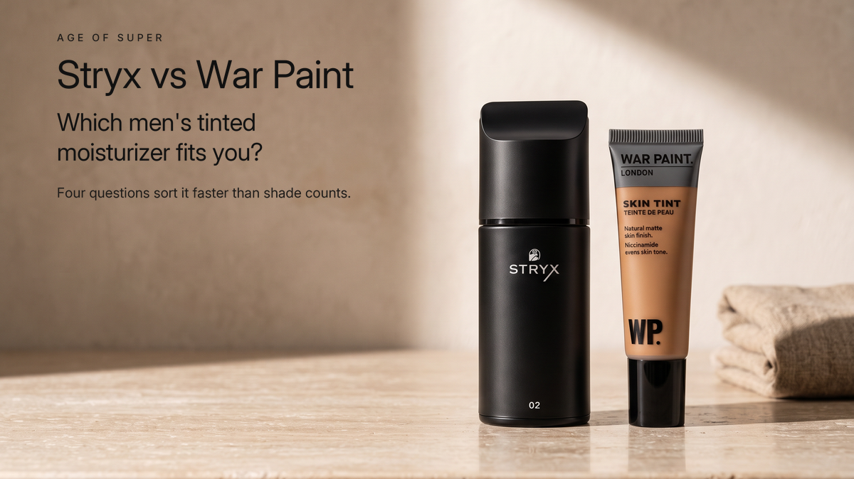 A matte black Stryx Product 02 Tinted Moisturizer bottle beside a War Paint for Men Skin Tint tube on a honed travertine stone counter in morning sunlight, beside the title "Stryx vs War Paint, which men's tinted moisturizer fits you?"