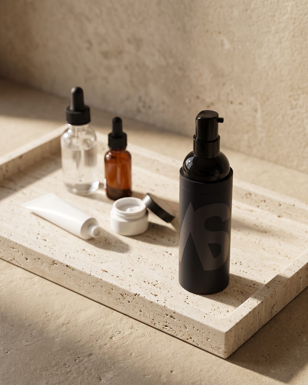 Stealth Blender pump bottle on a travertine tray in front of an unbranded skincare routine: serums with droppers, a tube and a cream jar
