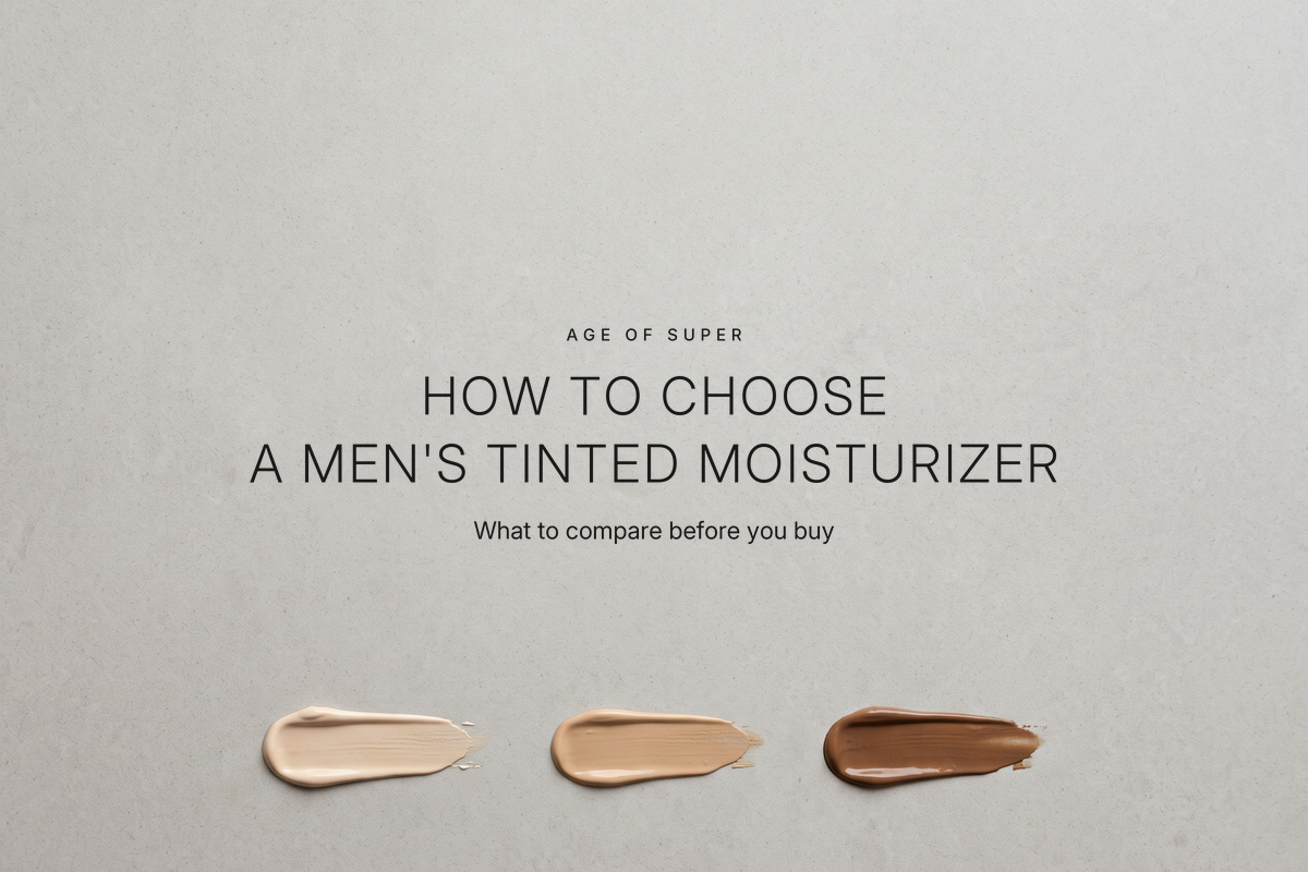 Centered text "How to choose a men's tinted moisturizer" with the line "What to compare before you buy" on a warm gray stone surface, above three small swatches of tinted cream in light, medium, and dark tones