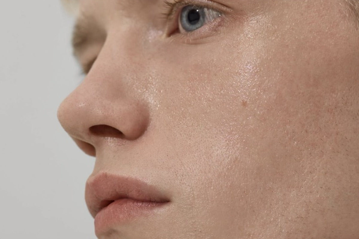 Close-up side profile of a man's face with natural-looking, even skin